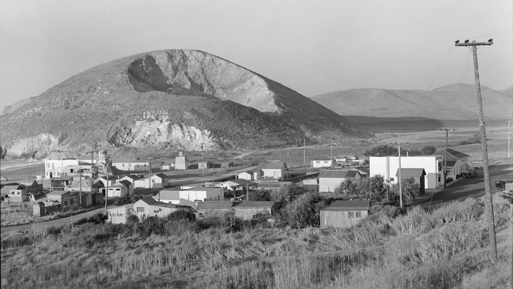 Historic 1938 photograph of Rockaway Quarry in Pacifica, California, showing the quarry hillside, early buildings, and surrounding coastal landscape captured by Dorothea Lange.