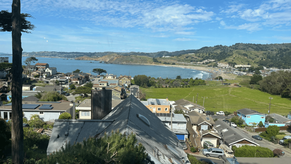 View from Pedro Point overlooking Linda Mar Beach in Pacifica CA, showing coastline, homes, and hillside neighborhoods